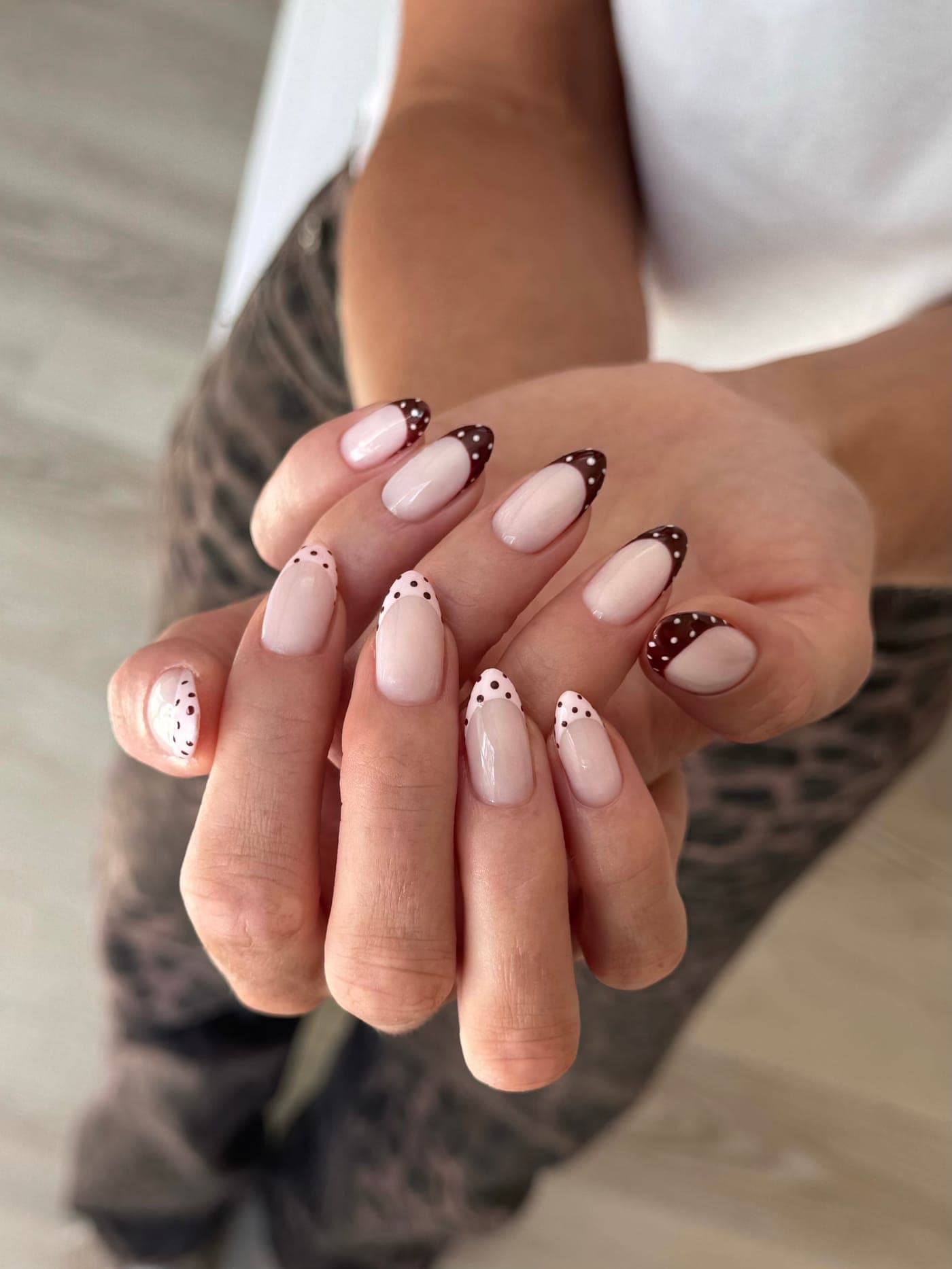 Playful brown and white polka dot french tip nail art